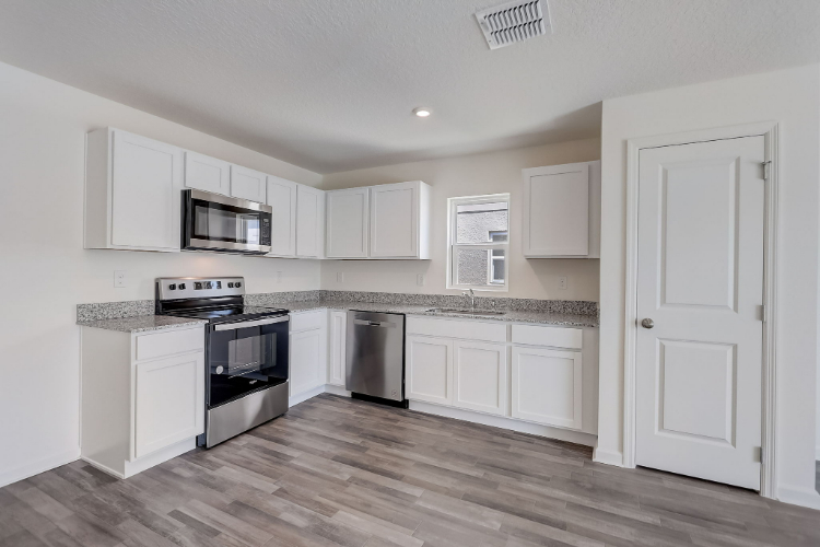 A kitchen with white cabinets.