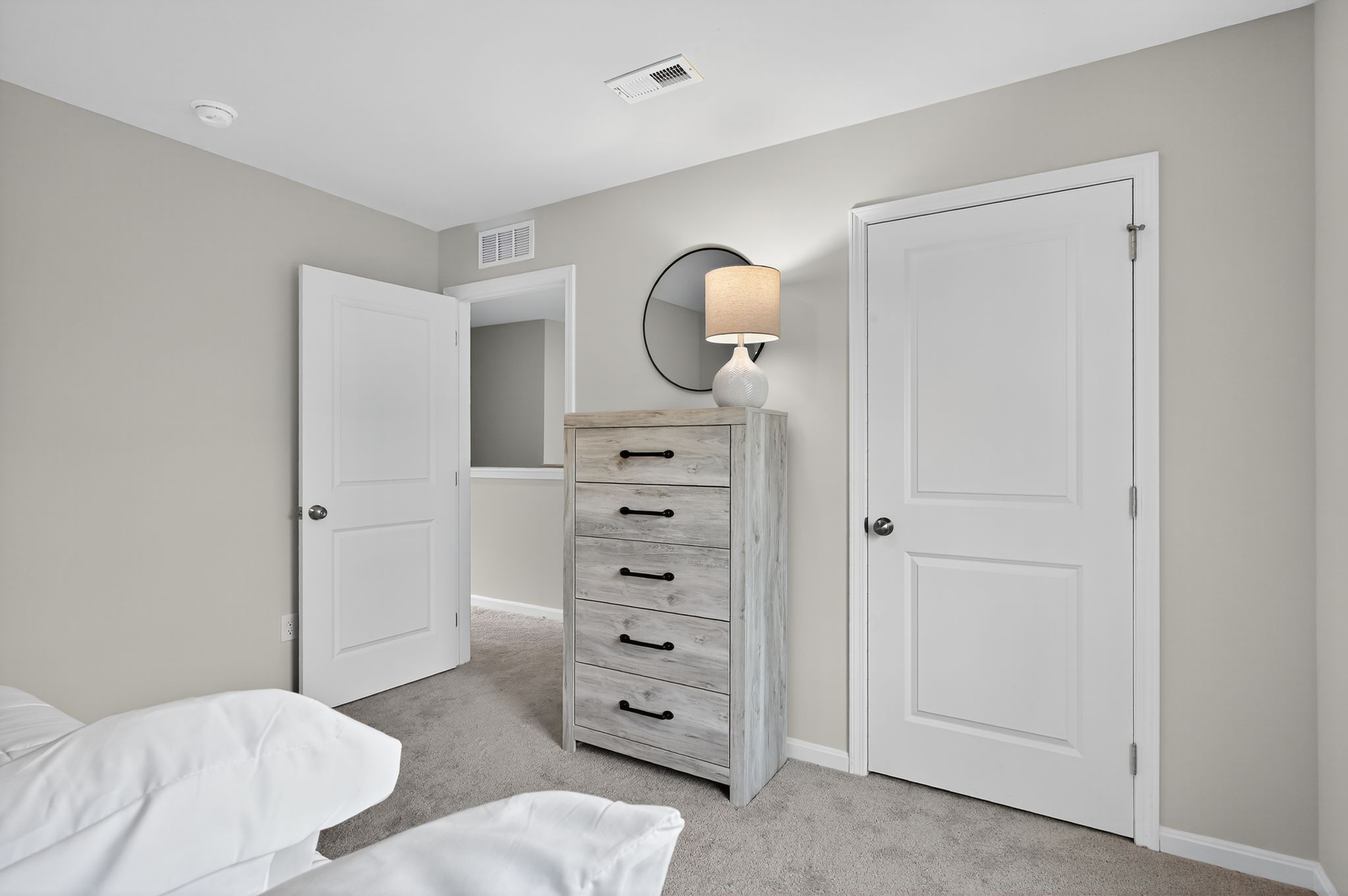 A bedroom with a dresser and a mirror.