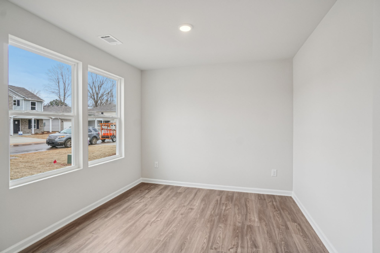 A room with a wood floor and a window with a wood floor.